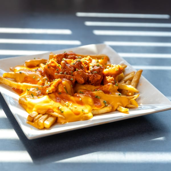 Ollie's Restaurant's American fries covered in melted cheese, buffalo chicken, and chives.
