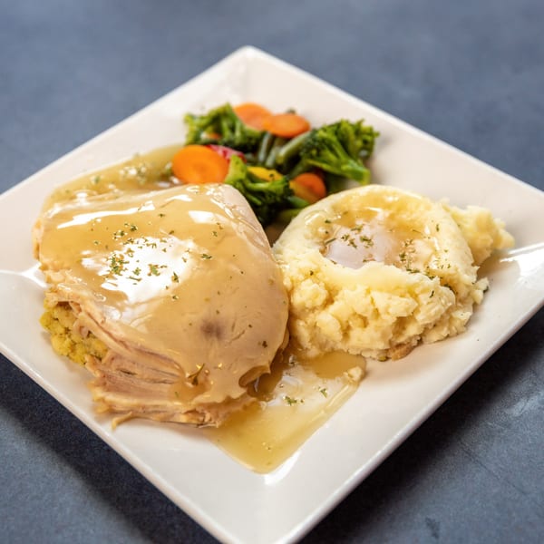 Ollie's Restaurant's American dish with turkey, mashed potatoes, gravy, and mixed vegetables.